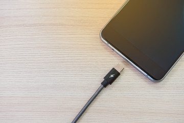 new technology digital smartphone and tablet wire charg on the table wood