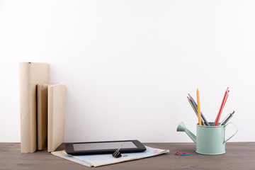 Books and stationery on a wooden office desk.