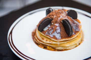Pancake decorate with chocolate powder and cookie