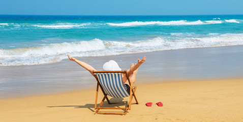 Happy woman  in white sunhat on the beach