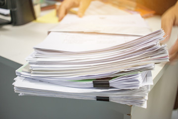 Stack of paper files on work desk in office