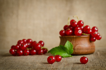 Red currant in wooden plate on the table