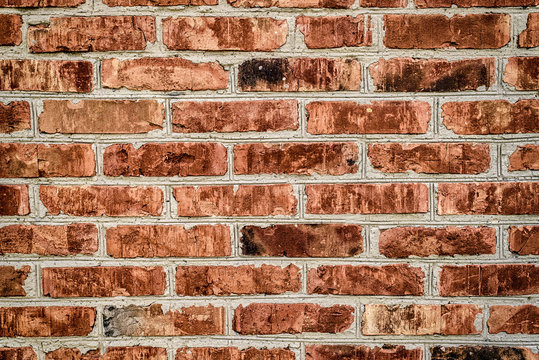 Grunge red brick wall background with copy space, texture pattern. Old texture of red stone blocks closeup, free space