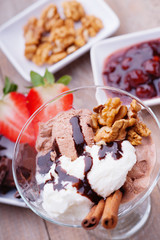 Ice cream sundae, chocolate, walnuts, sliced strawberry and jam 