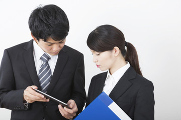 ビジネス　男女　タブレットを見ながら立ち話