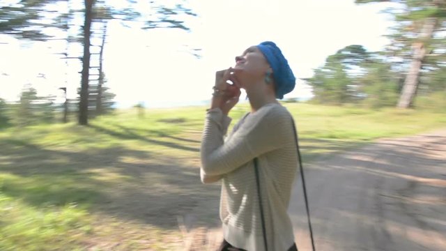 Happy woman in blue turban turning and spinning round in forest. holidays concept
