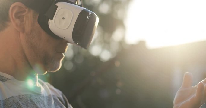Technology VR - Mature businessman wearing virtual reality technology googles / VR Glasses to work with in modern bright office. This new technology offers new 3D dimensions 4k