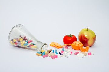 Colorful medical pills in a glass container on a white background.