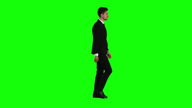 Man is going to a business meeting and waving greetings. Green screen. Side view