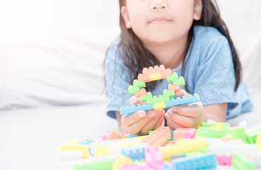 girl play block bricks on bed, education