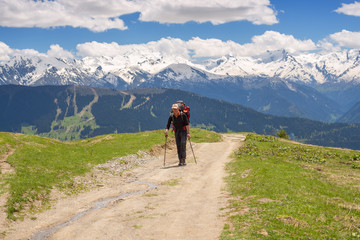 Naklejka na ściany i meble Traveler with big backpack in the mountains