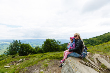Naklejka na ściany i meble Mother and daughter admire beauty in the mountains