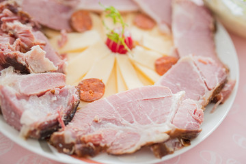 Slices of cooked ham on plate.