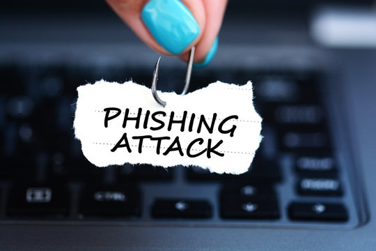 Phishing attack threat with woman hand holding fishing hook against laptop keyboard
