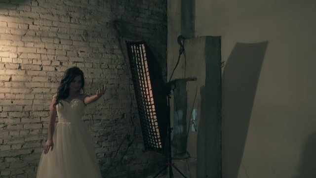 Photographing of young beautiful woman in wedding dress