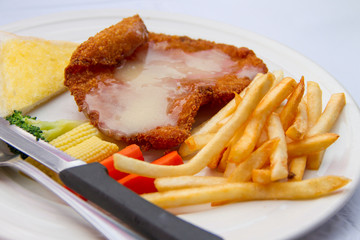 Fish steak with potato chips in white plate