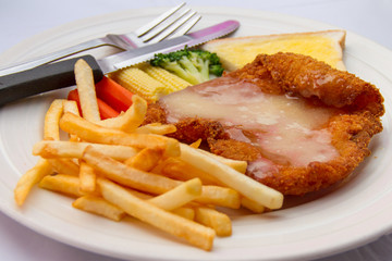 Fish steak with potato chips in white plate