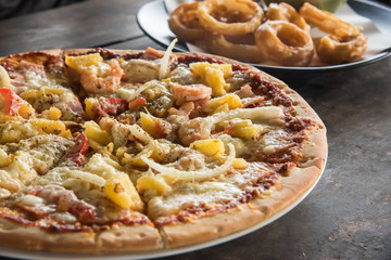 Delicious hawaiian pizza served on wooden table.