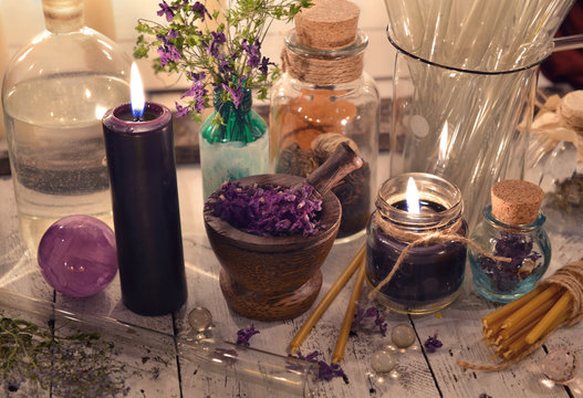 Black candles with glass jars and mystic objects. Mystic and occult still life, vintage background
