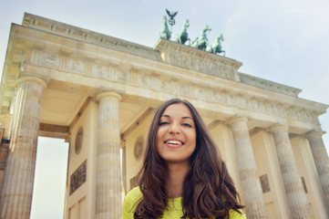 Happy smiling girl in front of Brandenburg Gate, Berlin, Germany. Beautiful young woman travel in Europe. © zigres