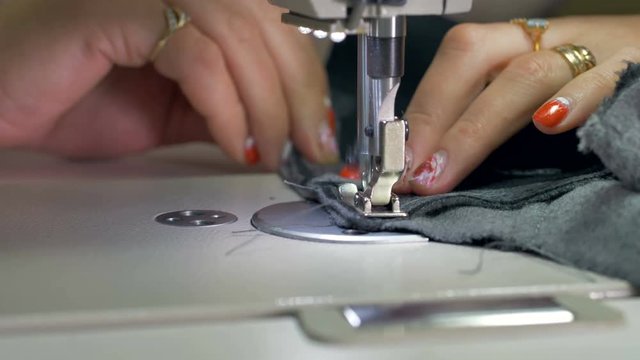 A tailor makes a reverse stitch. 