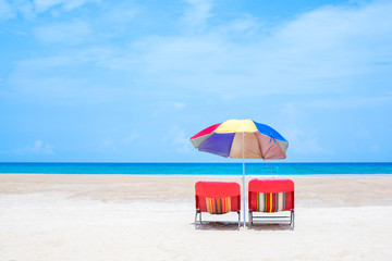 Beach chairs with umbrella and sand beach in summer.
