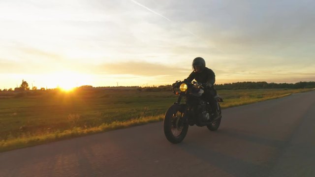 Riding vintage custom made cafe racer on a sunset