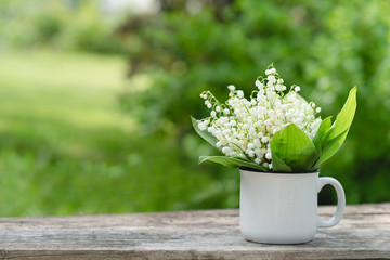 Summer  garden with lily of the valley flowers on wooden background