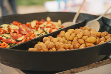 Catering outdoor, big pan with roast potato and vegetables