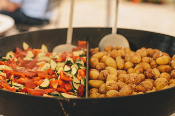 Catering outdoor, big pan with roast potato and vegetables
