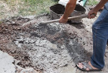 Obraz premium Worker stirs concrete shovel