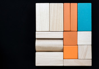 Sorted wooden blocks on black background. Copy space