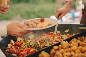 Catering outdoor, big pan with roast potato and vegetables