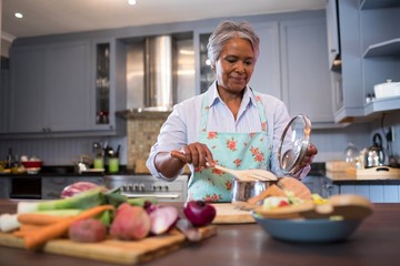 Senior woman preparing food in kitchen