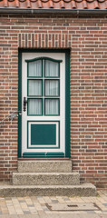 Fototapeta na wymiar Grün weiße Haustür mit Sprossenfester