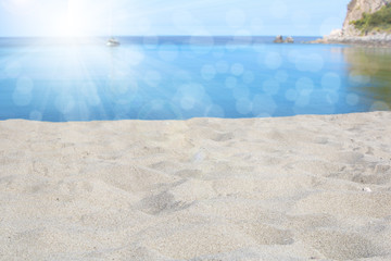 Summer scenario, white and fine sand, blue sea under a shining sun with a blurred background