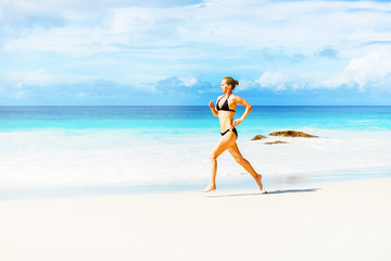 Photo of the young woman jogging on the beach