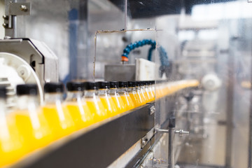 Bottling factory - Orange juice bottling line for processing and bottling juice into bottles. Selective focus. 