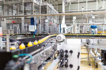 Bottling factory - Orange juice bottling line for processing and bottling juice into bottles. Selective focus. 