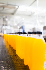 Bottling factory - Orange juice bottling line for processing and bottling juice into bottles. Selective focus. 