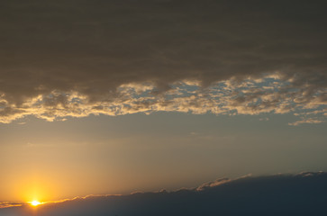 sun goes over a dark cloud. Sunset