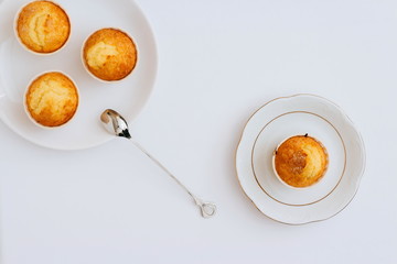 Homemade orange muffins in a plate on a white background