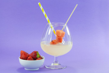 glass of refreshing drink: lemonade with a bowl of strawberries