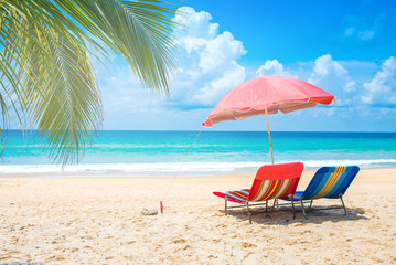 Obraz na płótnie Canvas Beach chairs with umbrella and sand beach in summer.