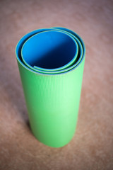 yoga mat green and blue rolled up