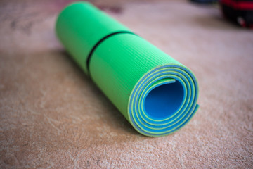 yoga mat green and blue rolled up