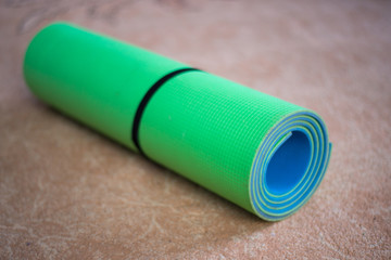 yoga mat green and blue rolled up