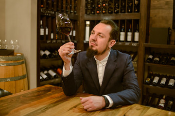 Young sommelier on red wine in cellar