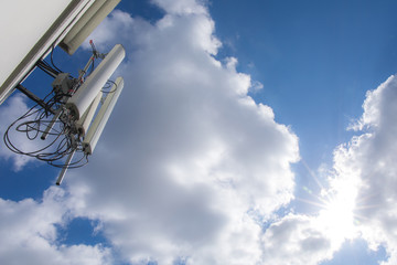 radio, tv or telephone transmitter with blue sky clouds and sunlight.