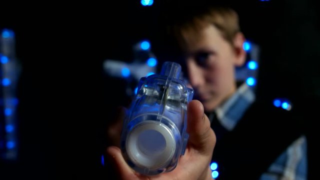 Boy with a laser tag gun takes aim at the camera